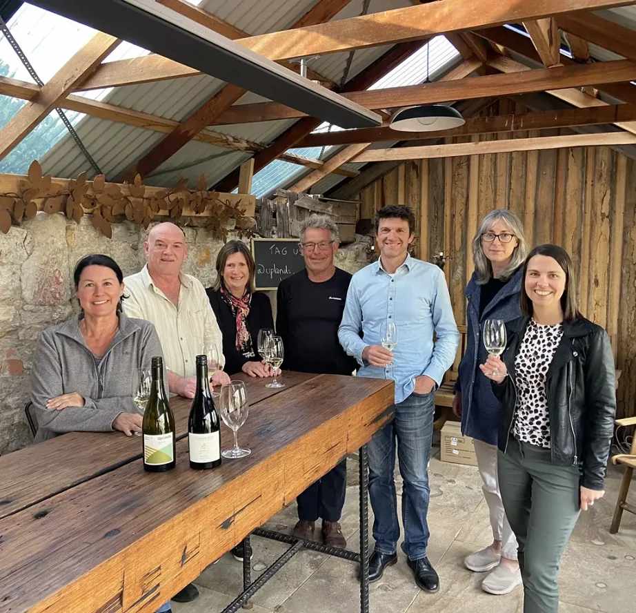 Members of the Wine South Tasmania committee standing at a timber bar in a cellar door